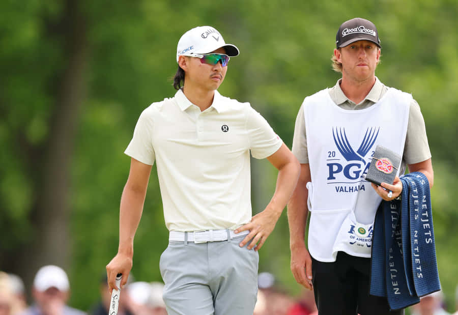 Golferand Caddie Walkingon Course Wallpaper