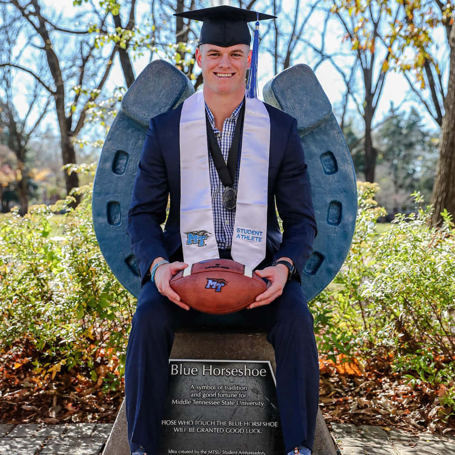 Graduate Athletewith Footballand Horseshoe Wallpaper