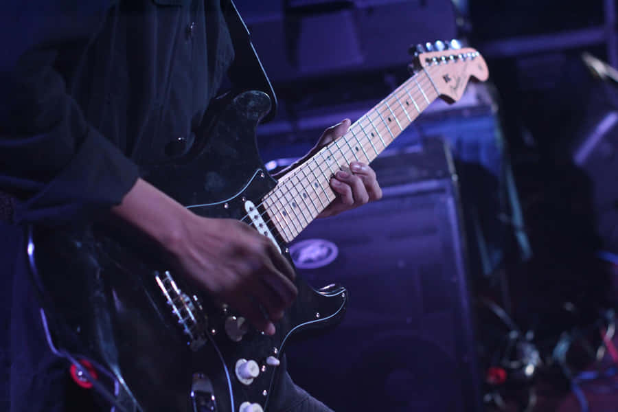 Guitarist Performing Live On Stage.jpg Wallpaper