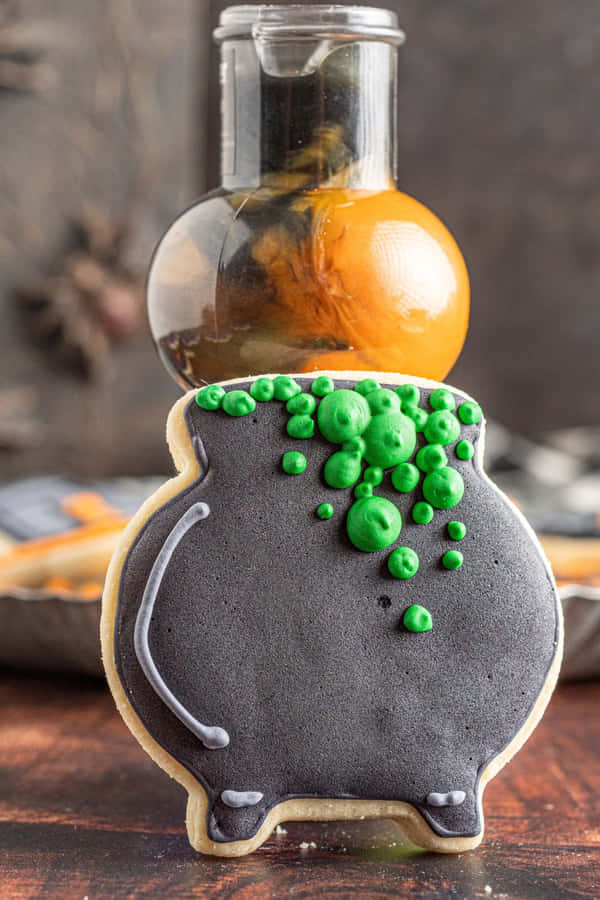 Halloween Cauldron Cookie With Green Bubbles Wallpaper