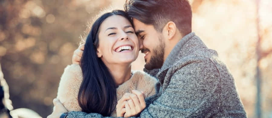 Happy Couple Embracing Outdoors Wallpaper
