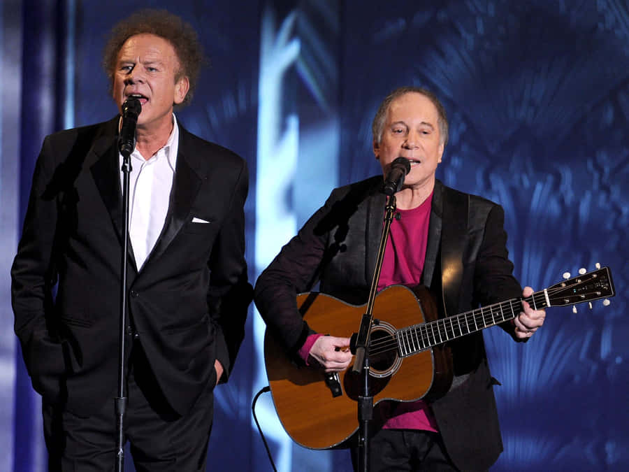 Iconic Duo Paul Simon And Art Garfunkel Performing Together Wallpaper