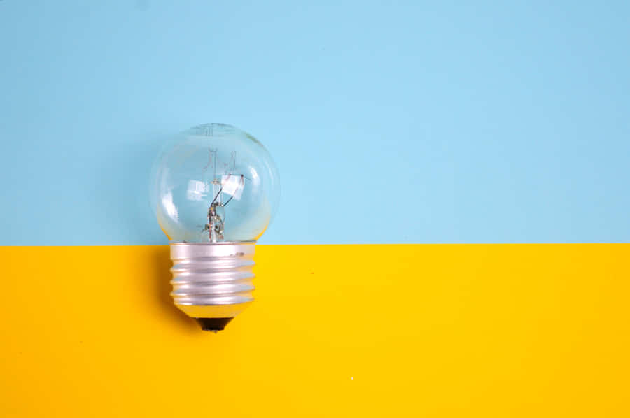 Incandescent Bulb On Yellow Surface Wallpaper