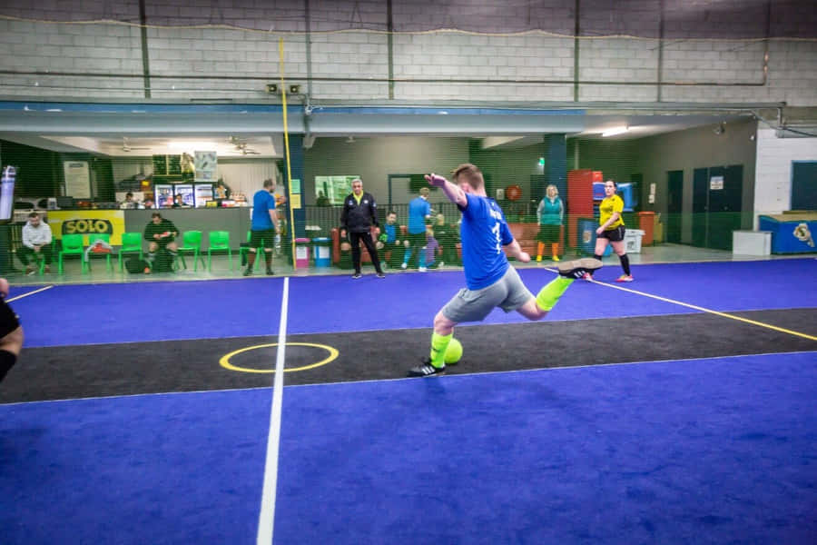 Indoor Soccer Player Kicking Ball Wallpaper