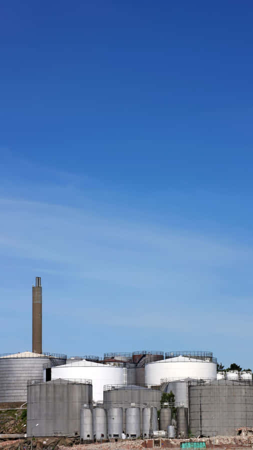 Industrial Storage Tanks Against Blue Sky.jpg Wallpaper