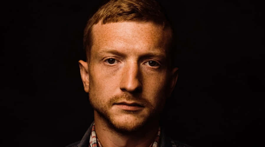 Intense Portraitof Manwith Shadowed Background Wallpaper