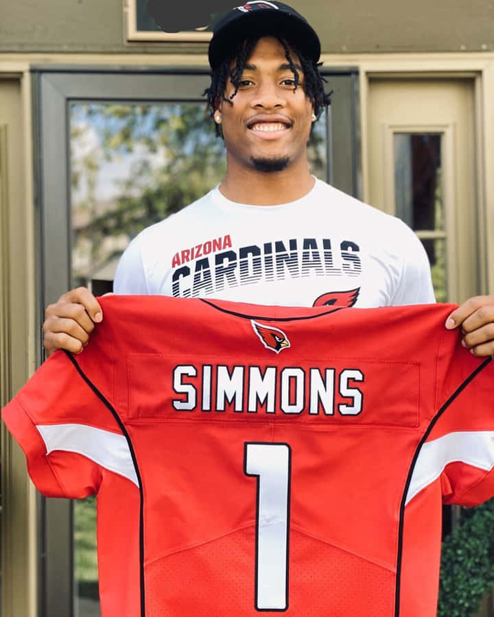 Isaiah Simmons Holding Cardinals Jersey Wallpaper