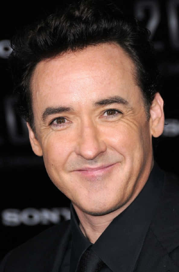 John Cusack Posing With A Quirky Expression For A Photoshoot Wallpaper