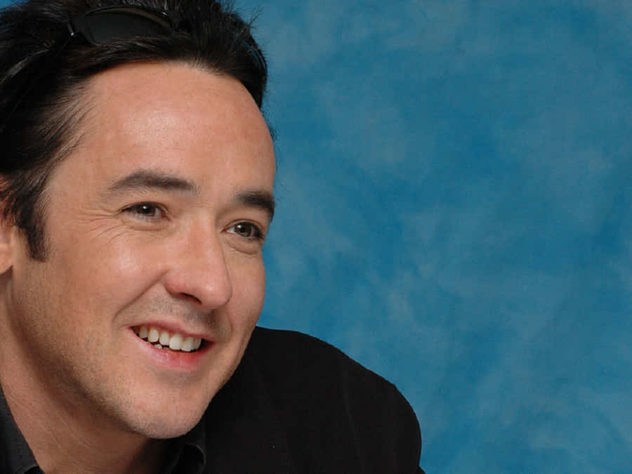 John Cusack Standing In A Stylish Pose Wallpaper