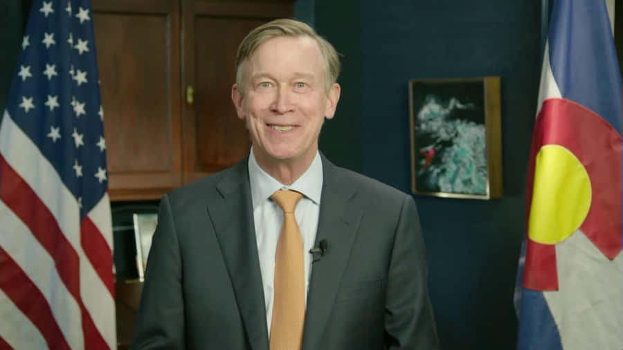 John Hickenlooper Standing In Front Of American Flag Wallpaper