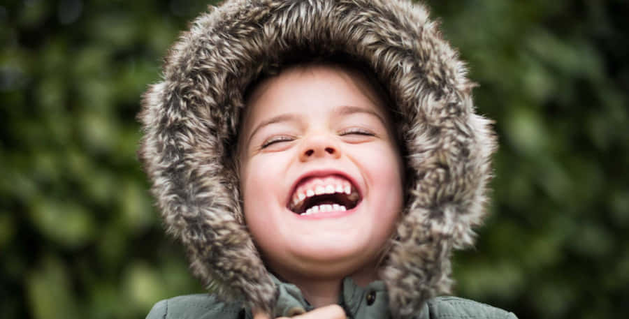 Joyful Child Laughing Outdoors.jpg Wallpaper