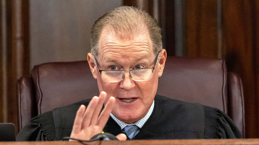 Judge Gesturing During Court Session Wallpaper