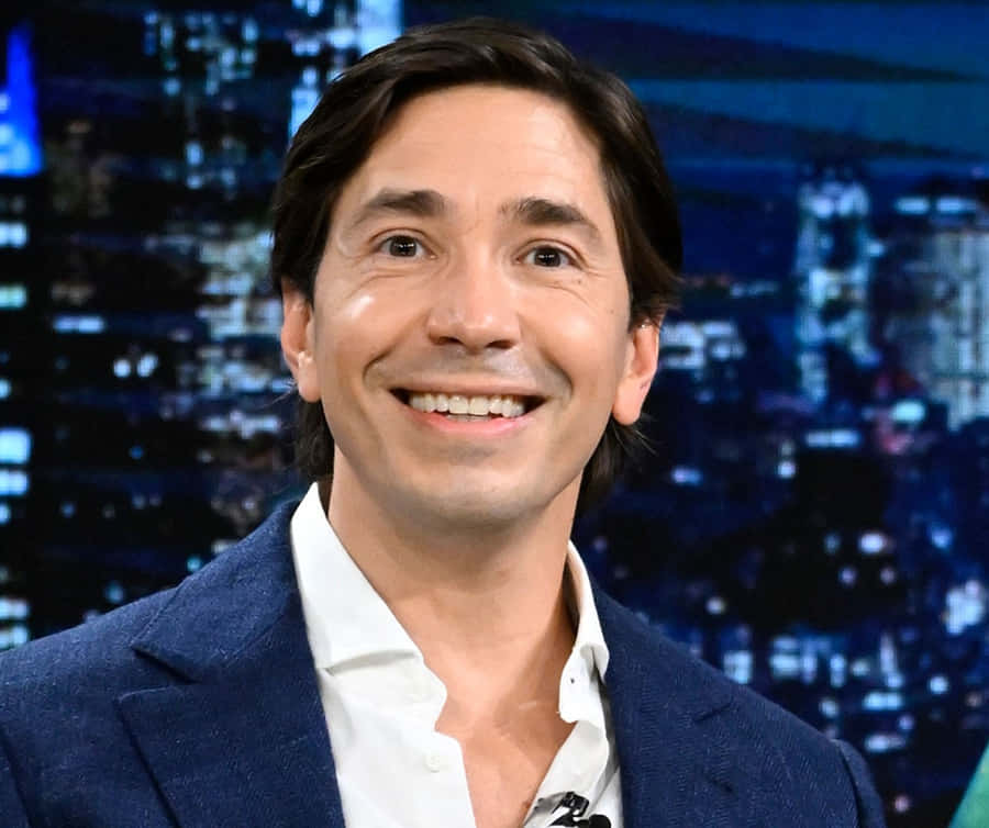 Justin Long Smiling In A Blue Shirt Wallpaper