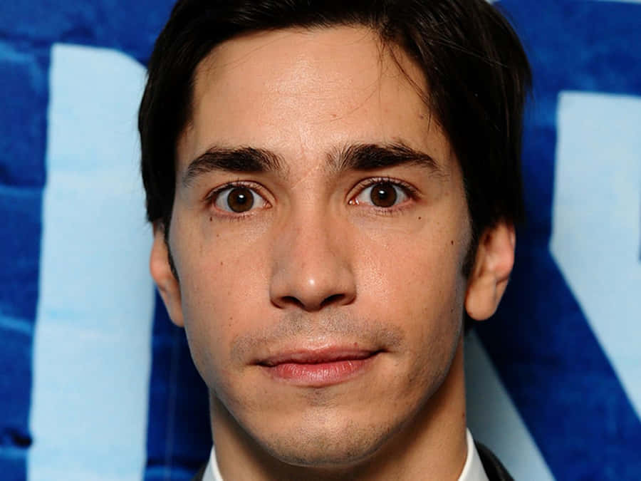 Justin Long Smiling On A Red Background Wallpaper