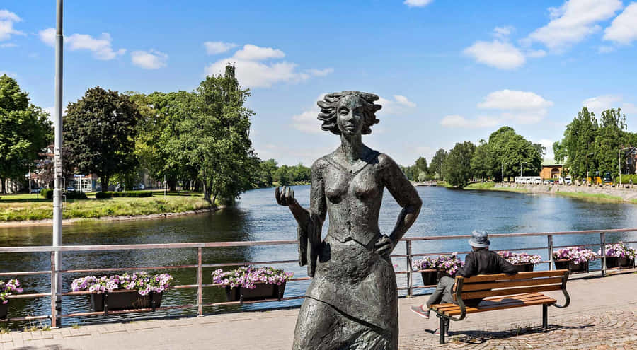Karlstad Riverside Sculptureand Bench Scene Wallpaper