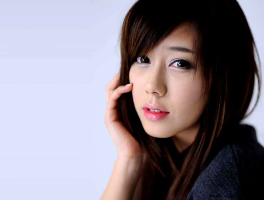 Korean Girl Showing Charm With A Hand Gesture Wallpaper
