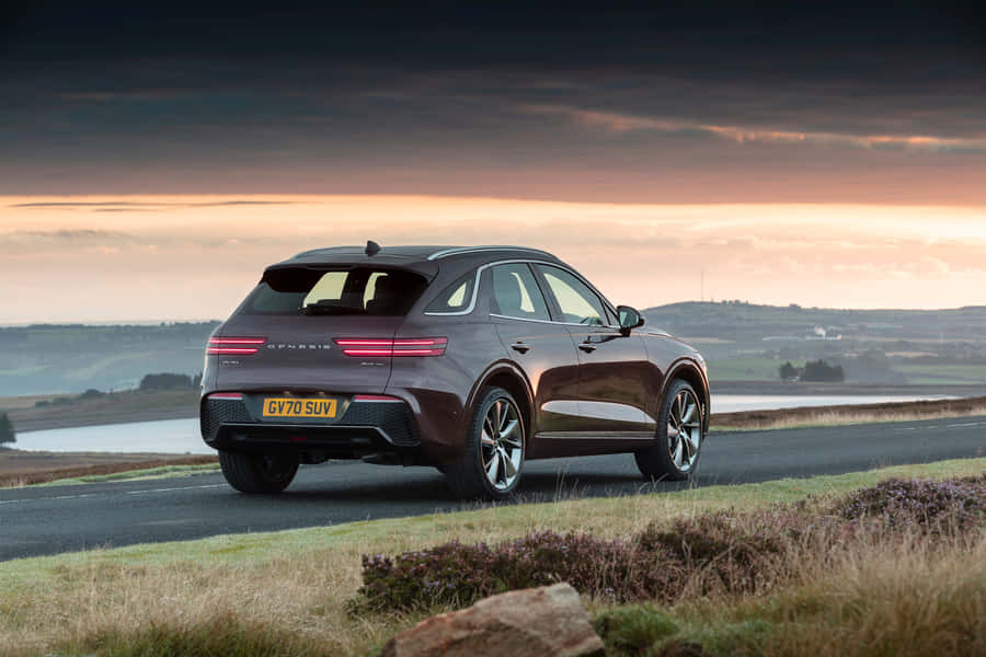 Luxurious Genesis Gv70 In Breathtaking Scenery Wallpaper