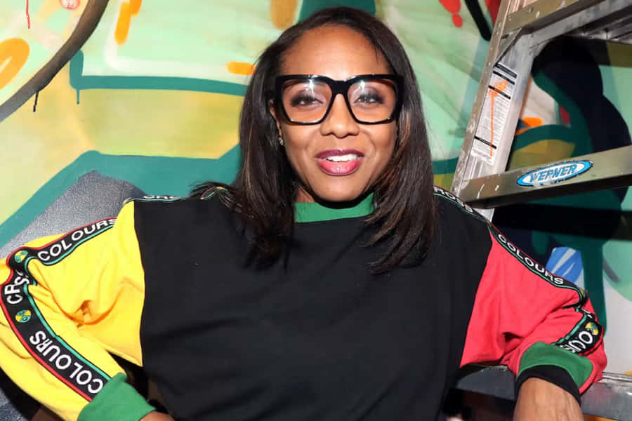 M C Lyte Smilingwith Colorful Backdrop Wallpaper