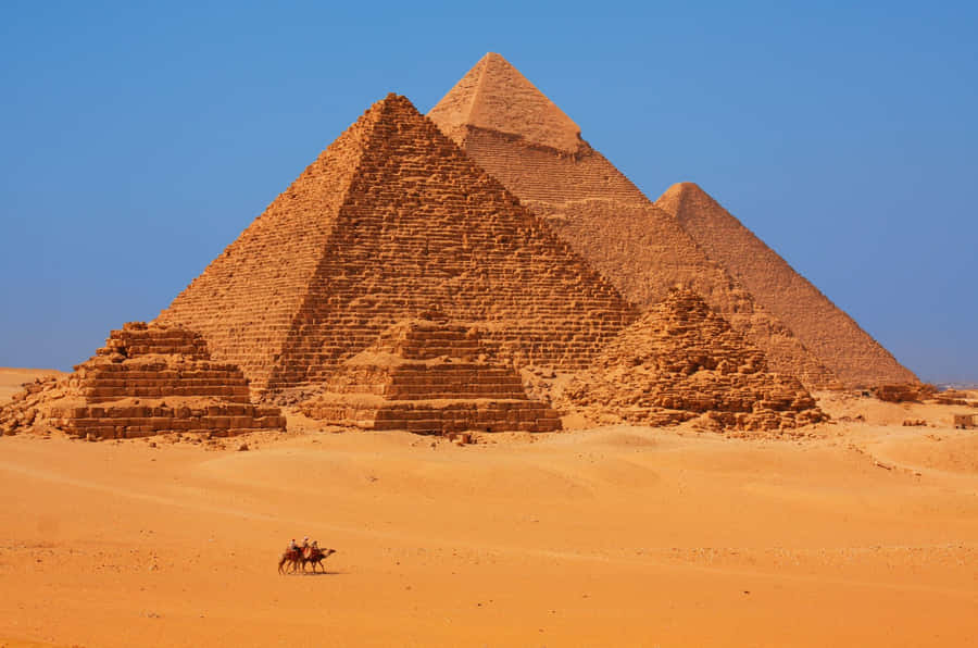 Majestic View Of The Pyramids Of Giza Bathed In A Rust-colored Hue. Wallpaper
