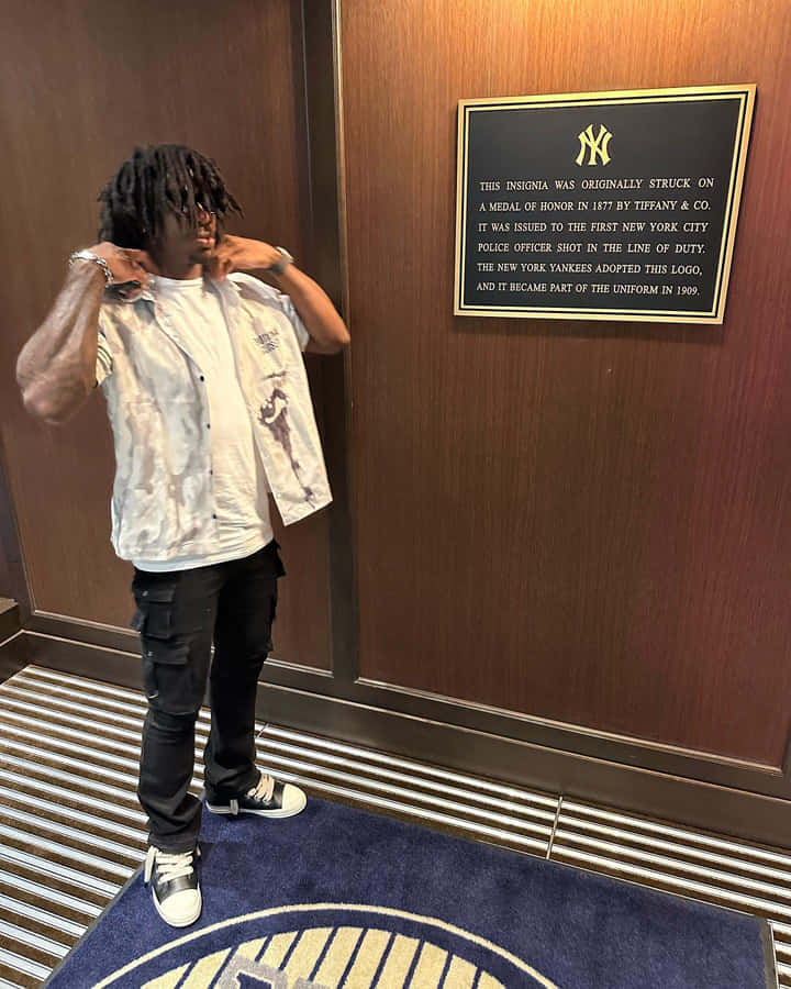 Man Adjusting Shirt Near Yankees Insignia Plaque Wallpaper