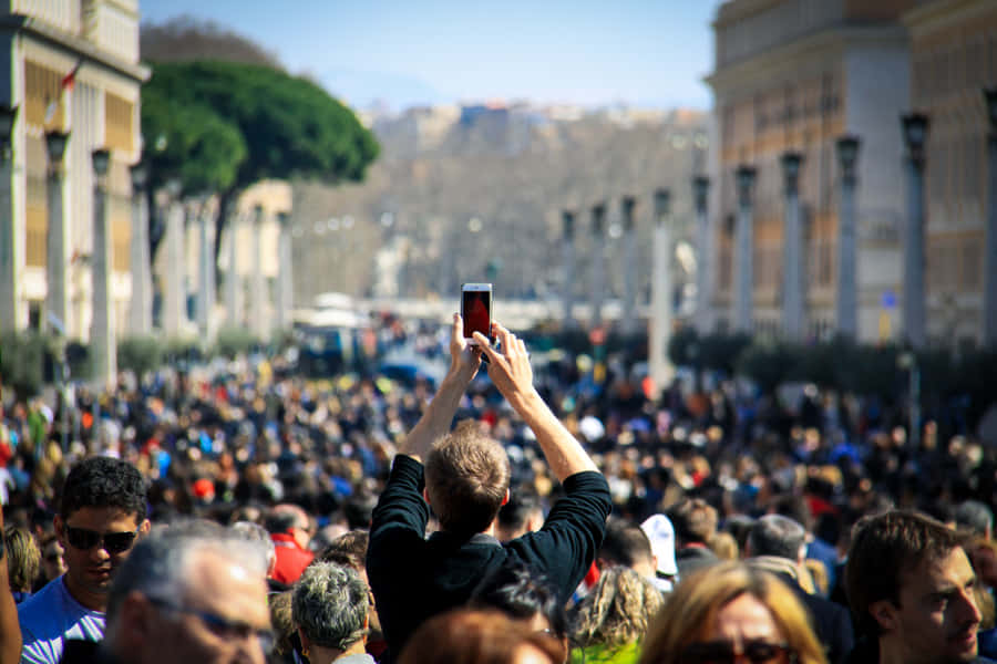 Man Looking Conspicuous With His Arms Raised For A Photo Wallpaper