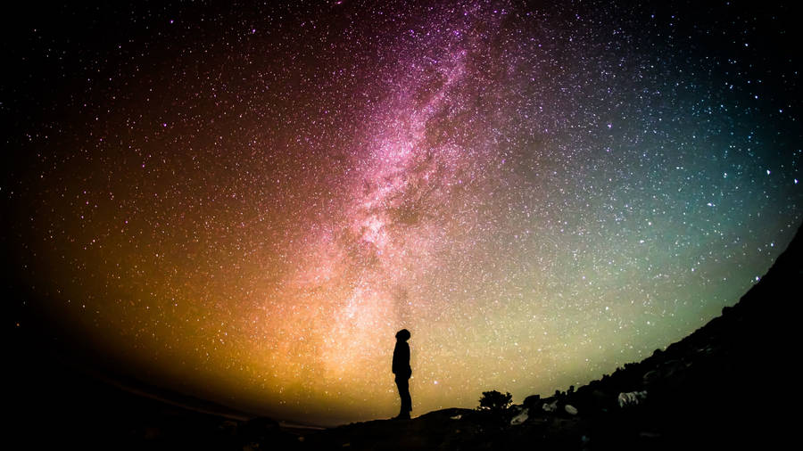 Man Looking Up At Rainbow Galaxy Wallpaper