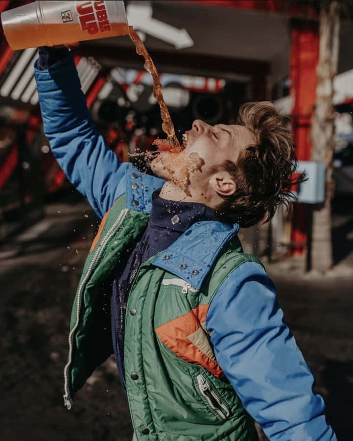 Man Spilling Drink Outdoors Wallpaper