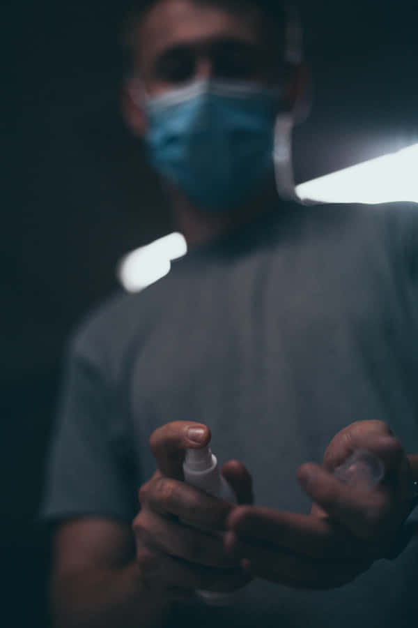 Man Using Antiseptic Hand Spray Wallpaper