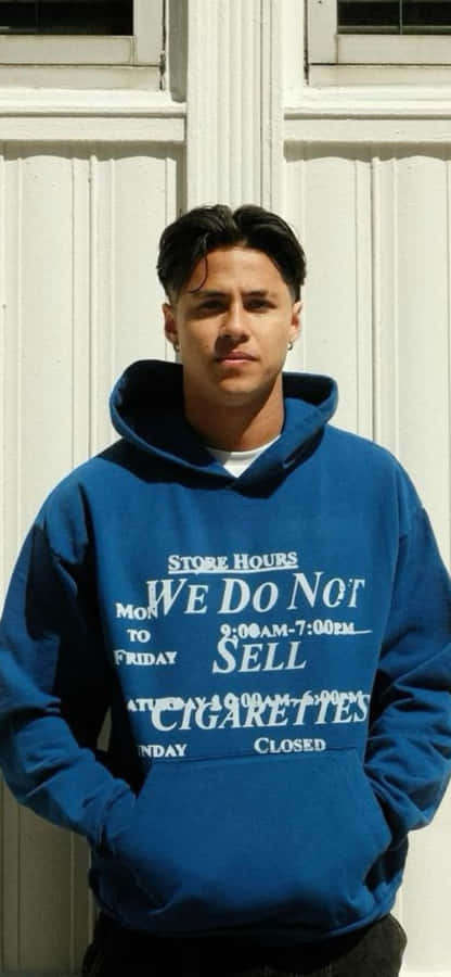 Manin Blue Hoodie Standing Against White Door Wallpaper