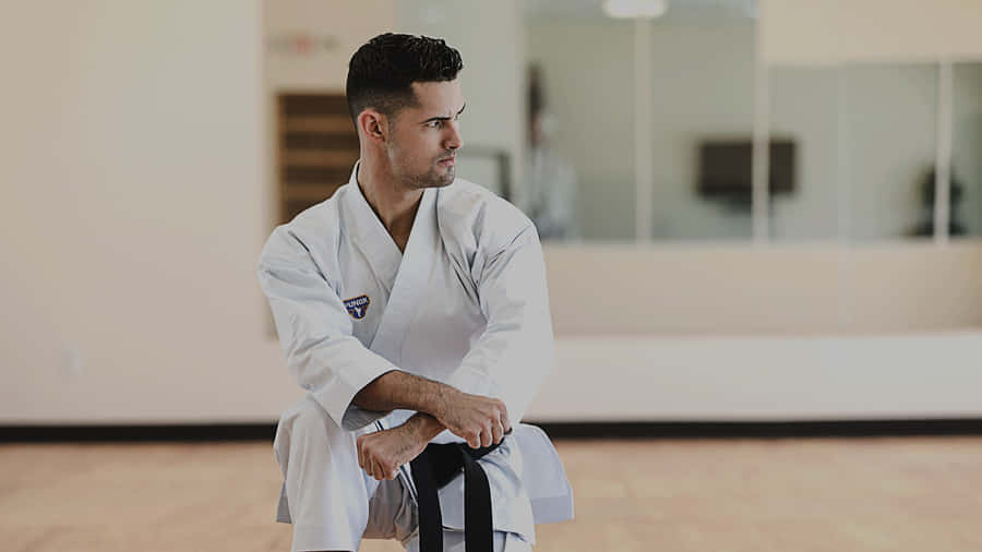 Martial Artist Wearing A Traditional White Uniform (gi) Wallpaper