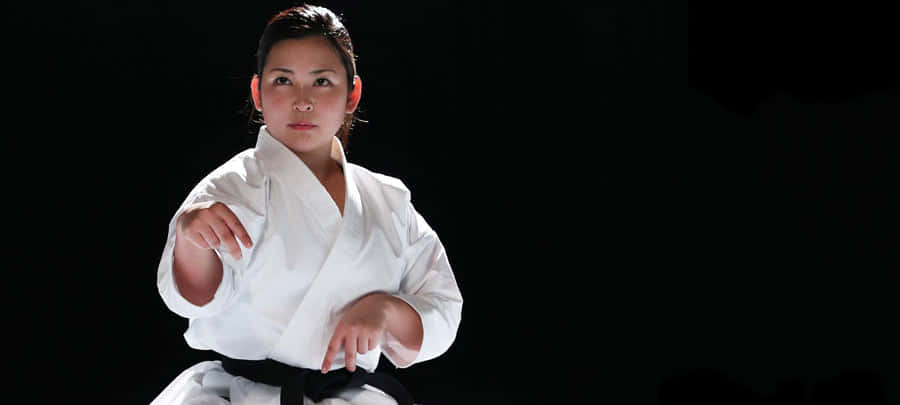 Martial Artists In Action Wearing Various Uniforms Wallpaper