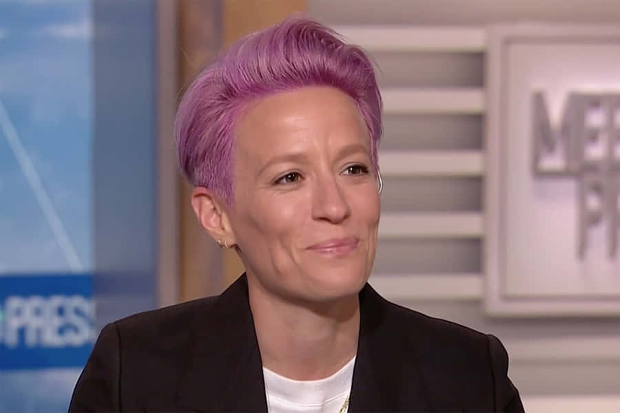 Megan Rapinoe In Action On The Soccer Field Wallpaper