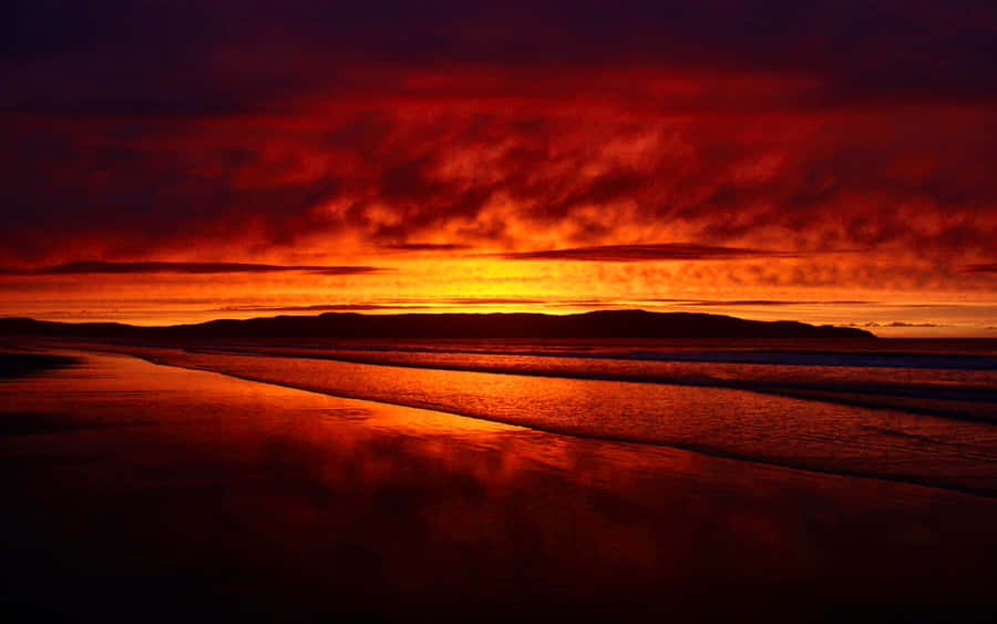 Mesmerizing Red Sunset At The Beach Wallpaper