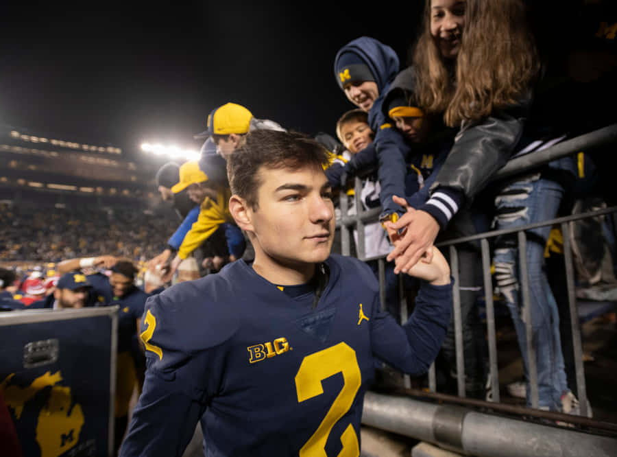 Michigan Football Playerwith Fans Wallpaper