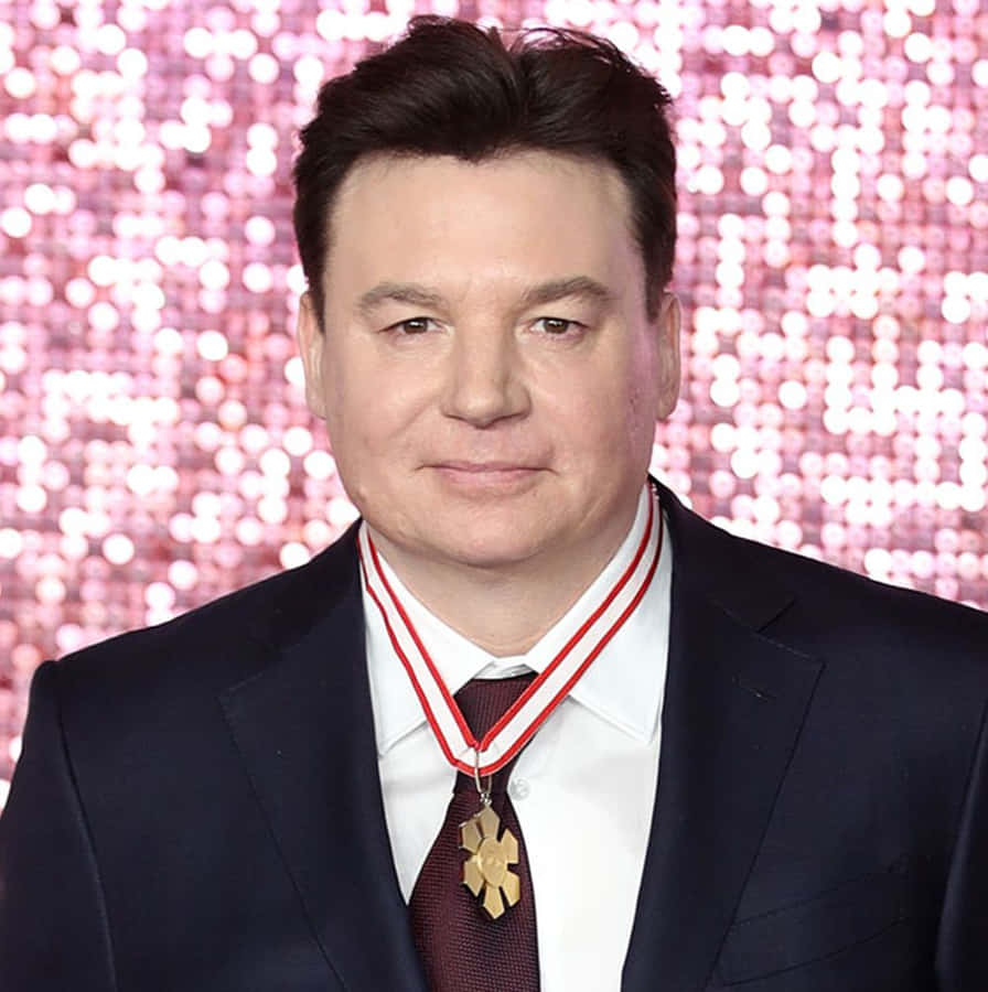 Mike Myers Looking Confident Against An Orange Background Wallpaper