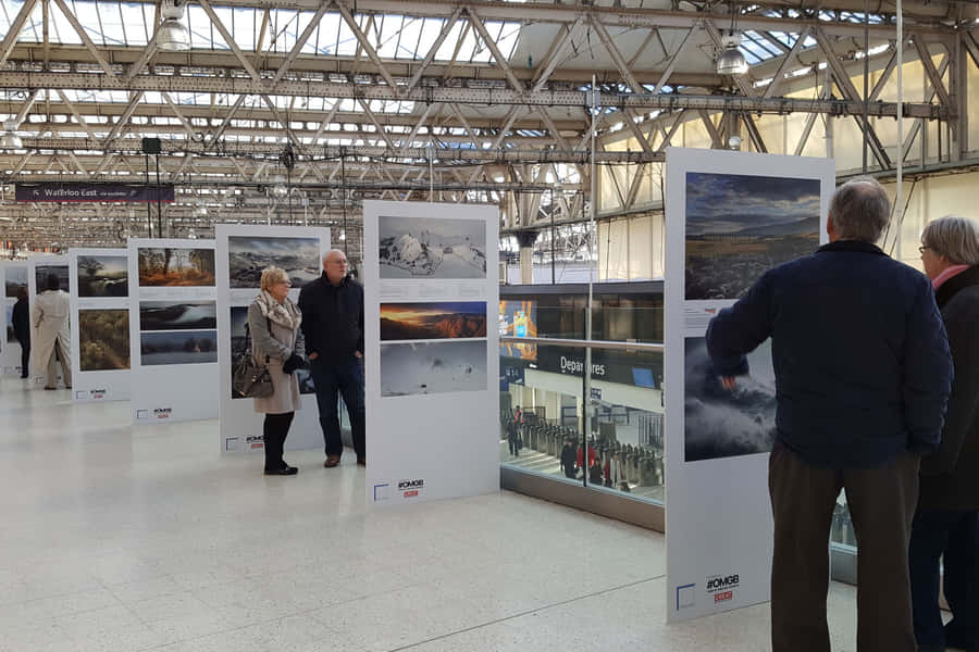 People Looking At Waterloo Station Exhibit Wallpaper