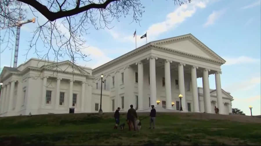 People Walking Their Pets Outside The Virginia State Capitol Wallpaper