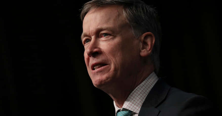 Permanent Governor John Hickenlooper Poses Against A Black Backdrop Wallpaper