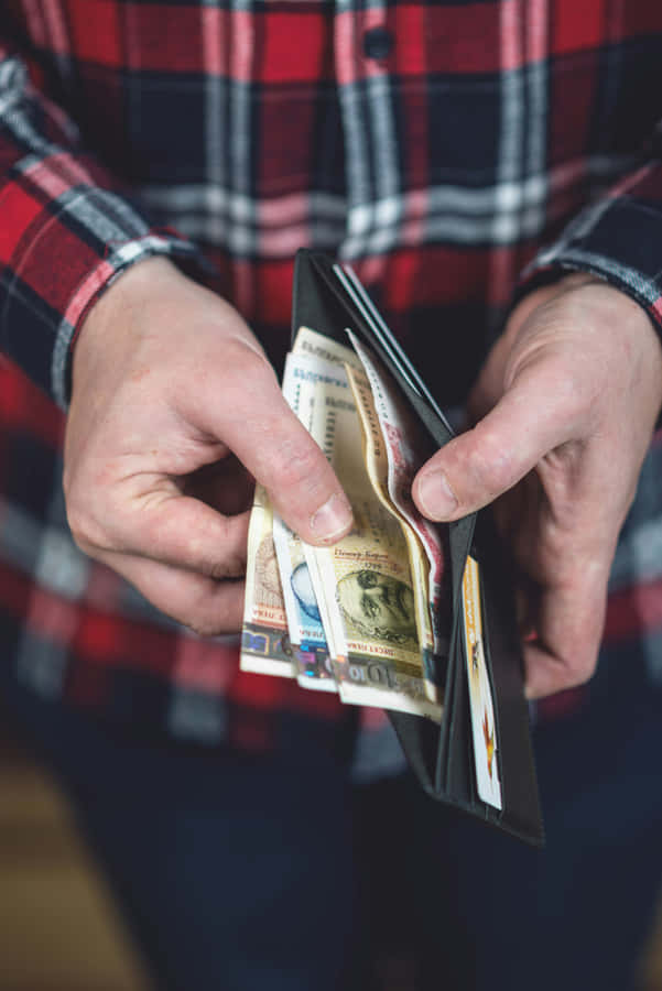 Person Holding Open Wallet With Cashand Cards Wallpaper