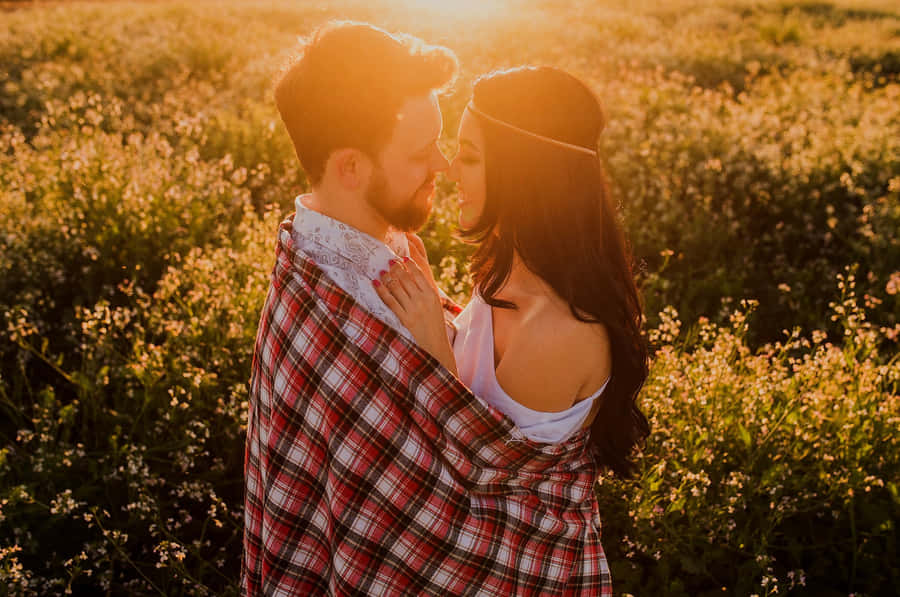 Picture Of A Couple Tangible Facing Each Other Closely On A Flower Field Wallpaper