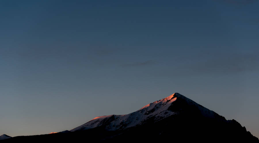 Picturesque Mountain Range With Clouds And The Horizon Beyond Wallpaper