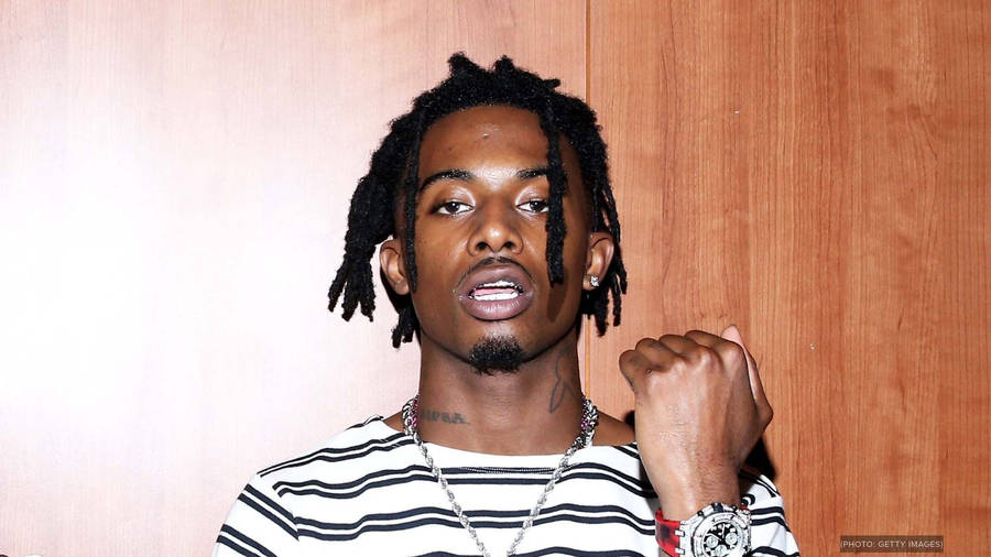 Playboi Carti Holds Fist Up In Adrenaline And Progress. Wallpaper