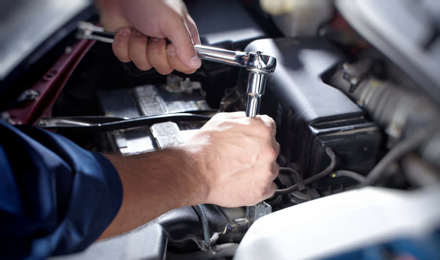 Professional Mechanic Repairing A Car In A Garage Wallpaper