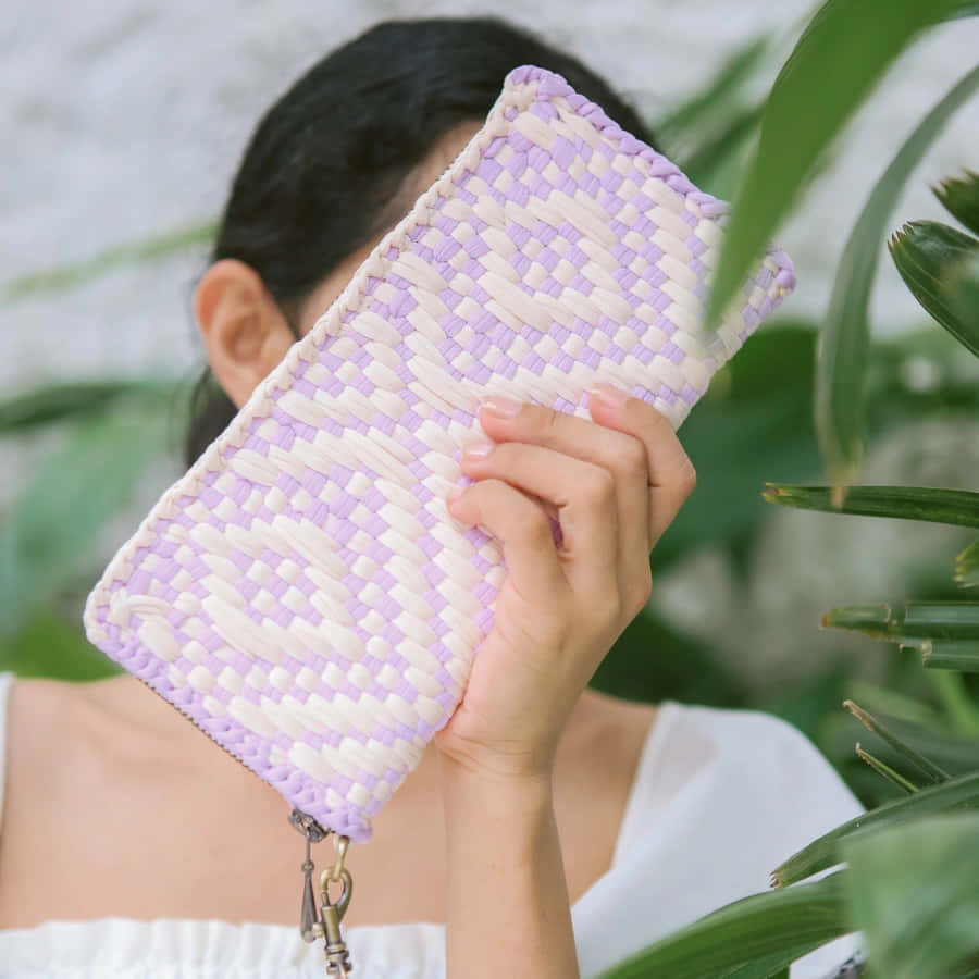 Purple And White Woven Wallet Held Up Wallpaper