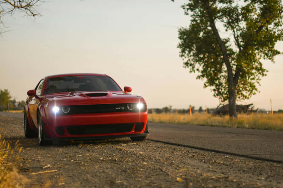 Red Sports Car On Roadat Dusk Wallpaper