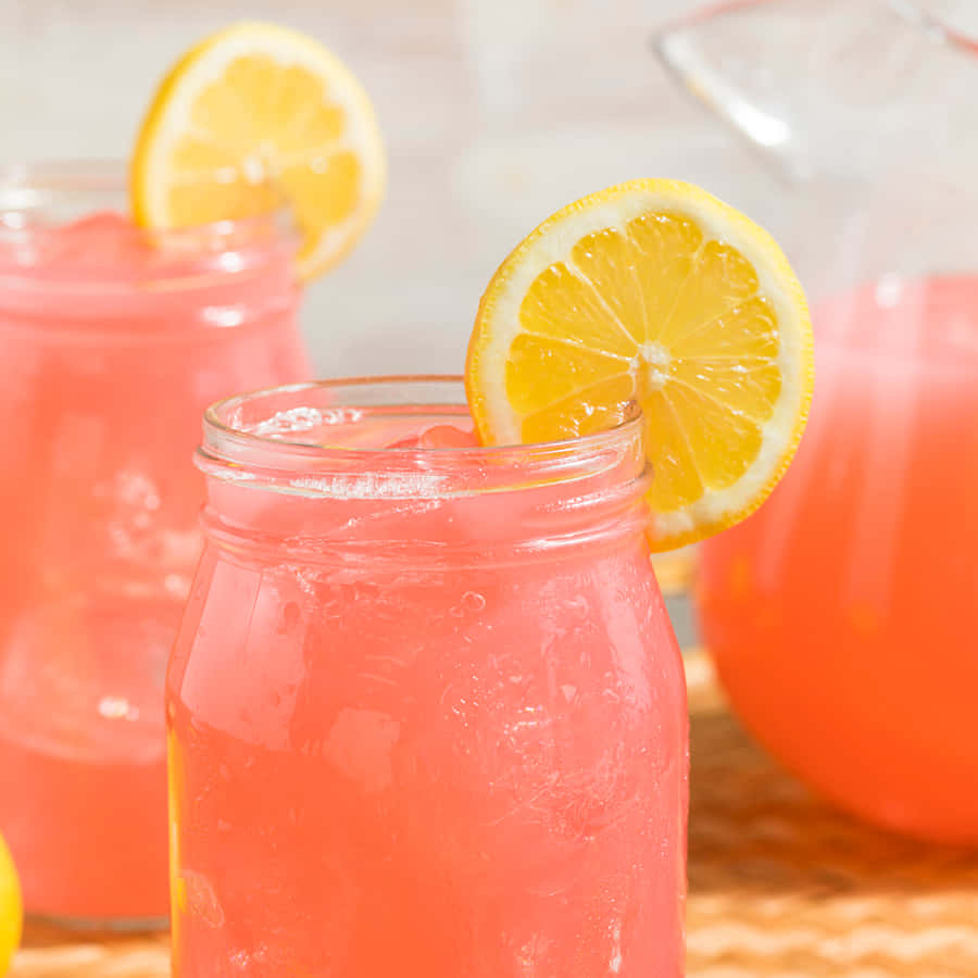 Refreshing Pink Lemonade In Glass With Lemon Slices Wallpaper