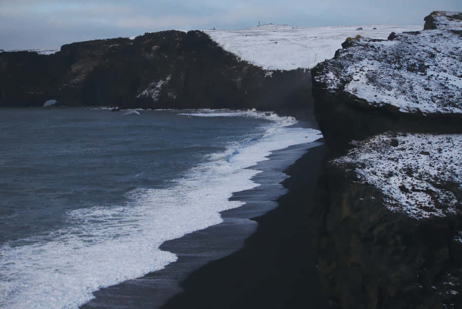Relax And Let The Sea Breeze Wash Away Worry At This Stunning Black Sand Beach. Wallpaper