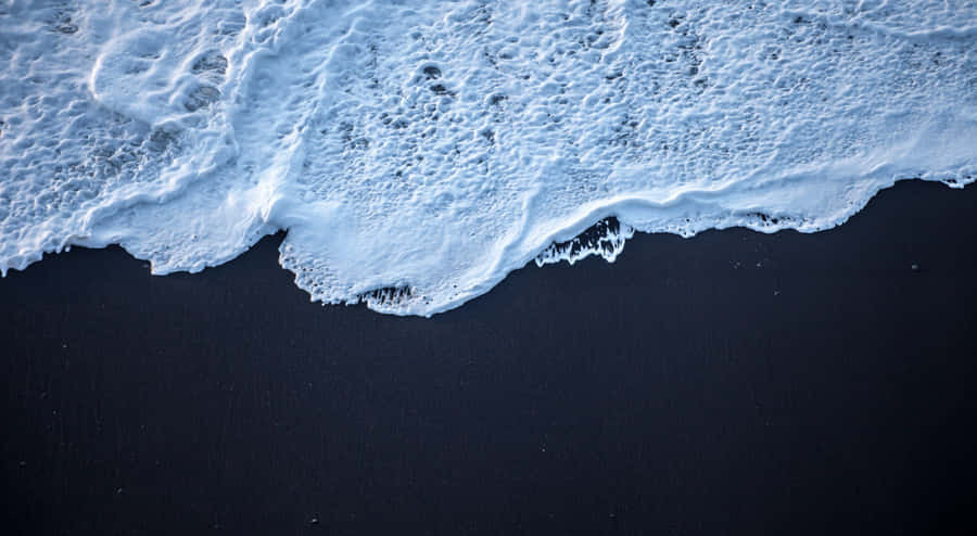 Relax On The Tranquil Black Sand Beach Wallpaper