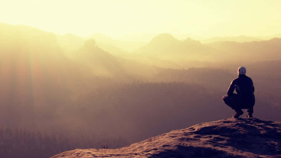 Resilient Sitting Alone Above A Mountain Wallpaper