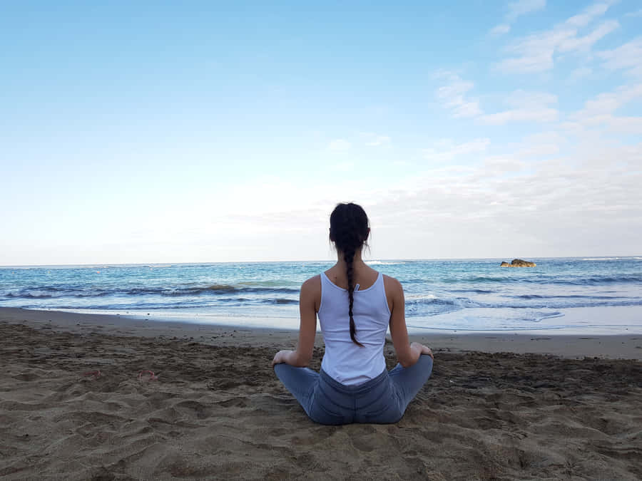 Resilient Woman Sitting Alone Beside The Beach Wallpaper